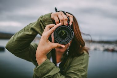 A young woman using a DSLR camera