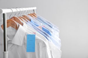 shirts from dry cleaners hanging on garment rack